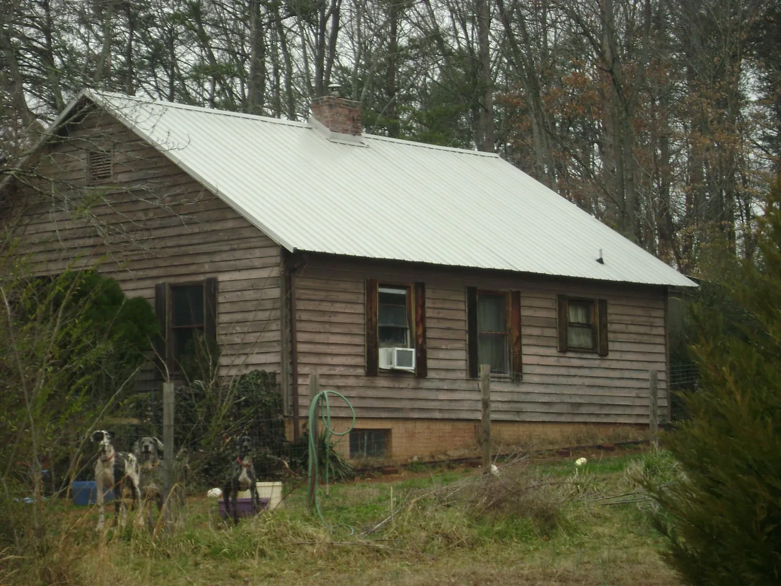 White metal roof on an old wood sided farmhouse, from a Metal Roof Installation job in Saginaw